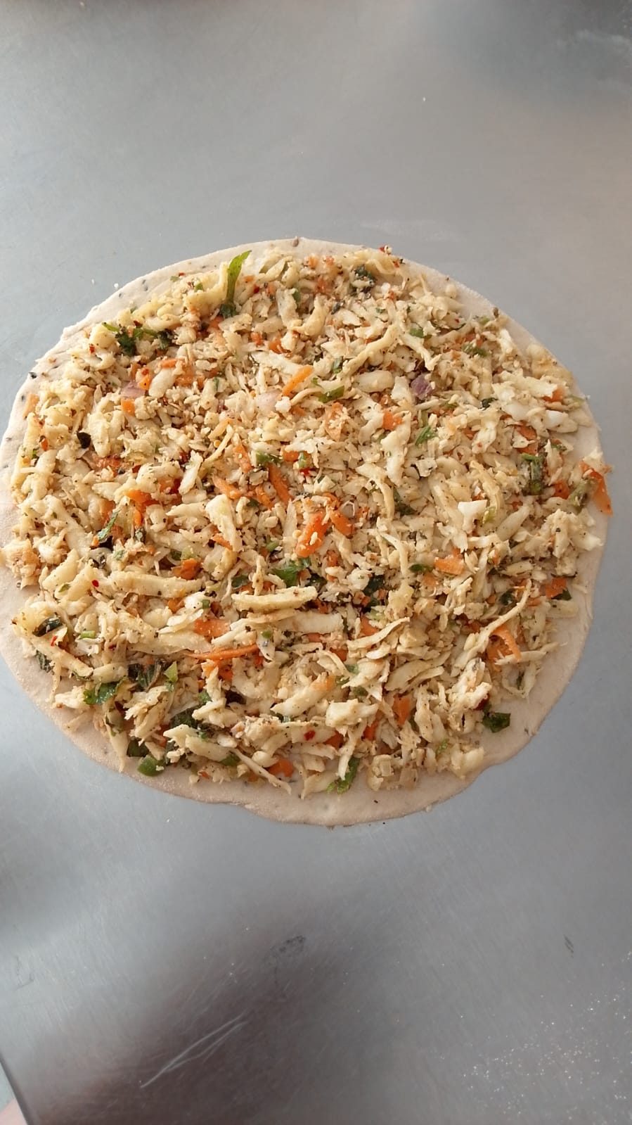 Freshly stuffed paratha dough, rolled and ready for the griddle